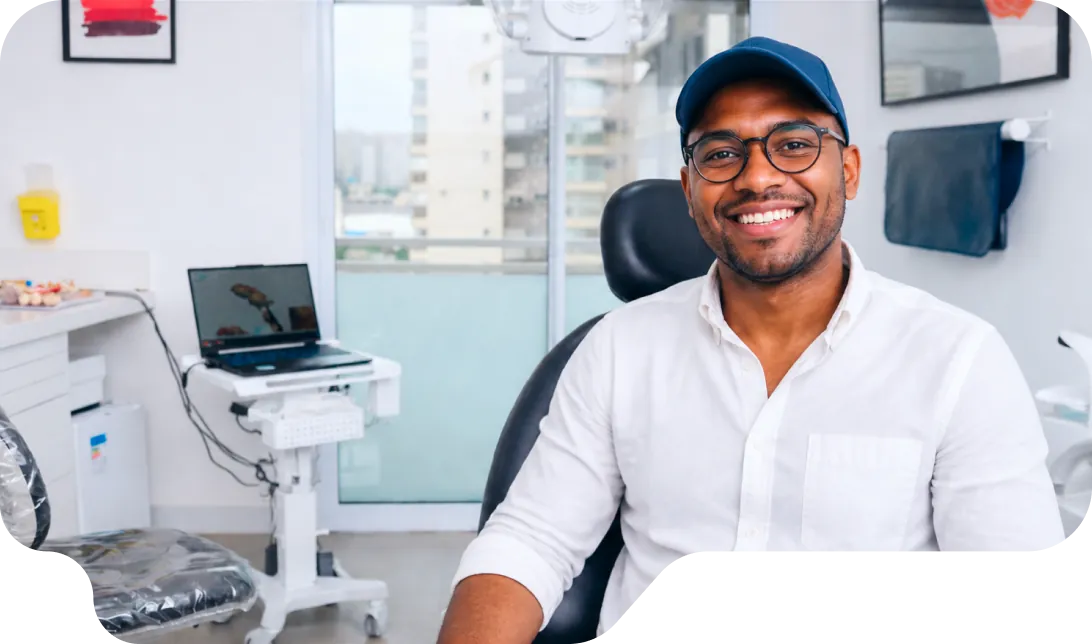 Paciente sorrindo na cadeira do consultório da Vital Odonto Implantes