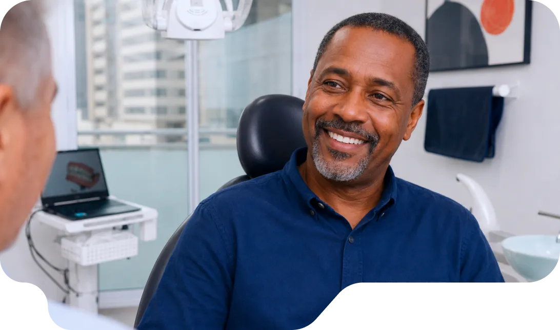 Paciente sorrindo na cadeira do consultório da Vital Odonto Implantes